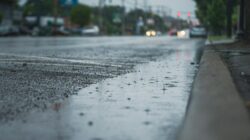 Pengendara melintas saat hujan di jalan utama Palembang (Chris F)