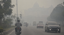 Kabut asap menyelimuti kawasan perkotaan dengan jarak pandang terbatas tanpa menampilkan wajah manusia