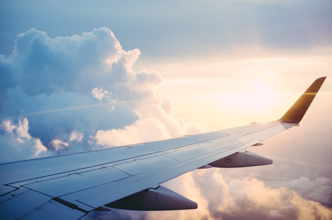 Ilustrasi pesawat terbang di antara awan untuk operasi modifikasi cuaca. Foto: Ross Parmly/Unsplash